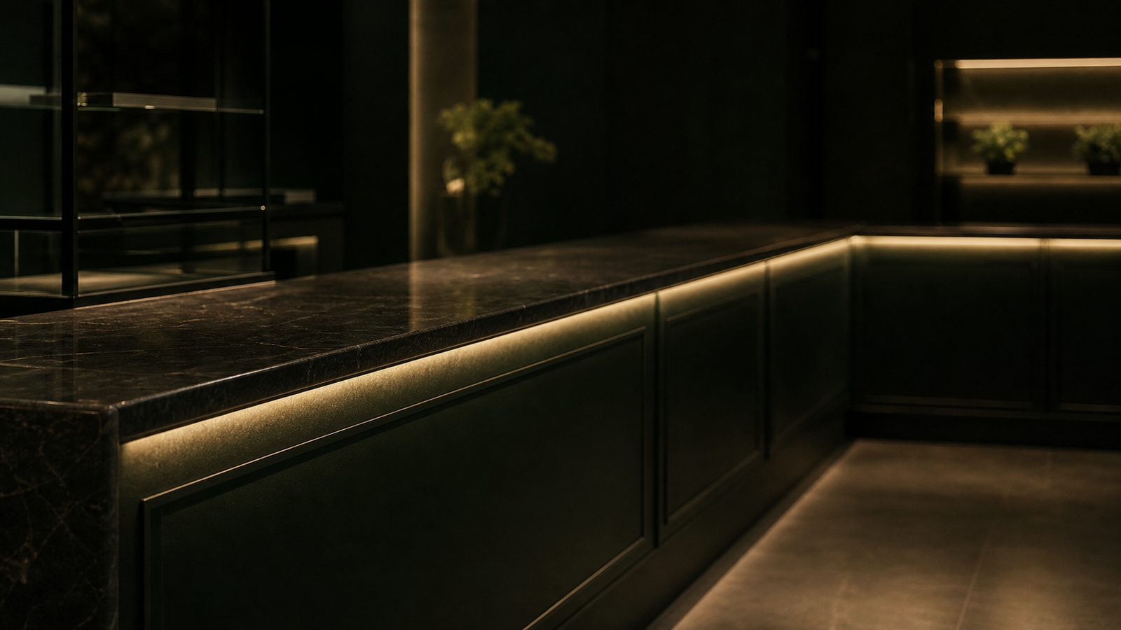 Dark stone dispensary service counter with green millwork and warm edge lighting